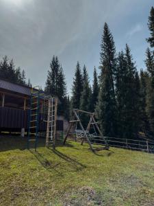 an empty playground with a ladder and a swing set at Kolsay Tanbalytas Villa in Kolʼbastau