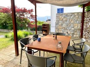 a wooden table and chairs on a patio at Casa Corten, Vista Lago in Cerro Lago Maggiore