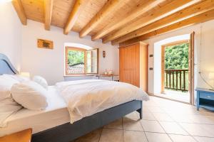 ein Schlafzimmer mit einem Bett und einem großen Fenster in der Unterkunft B&B Arlanch 8 in Vallarsa