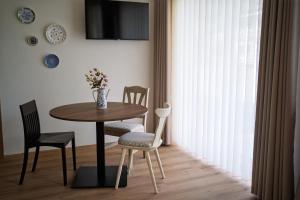 a dining room table with two chairs and a vase with flowers at Aparthaus Vergissmeinnicht in Söll