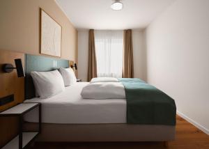 a hotel room with a large bed and a window at Limehome Braunschweig Kaiserstraße in Braunschweig +43 photos
