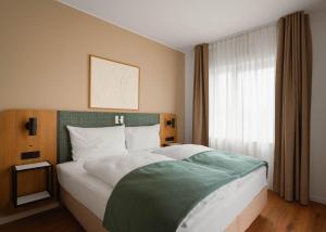 a bedroom with a large bed and a window at Limehome Braunschweig Kaiserstraße in Braunschweig