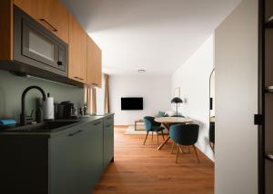 a kitchen with a sink and a table with chairs at Limehome Braunschweig Kaiserstraße in Braunschweig