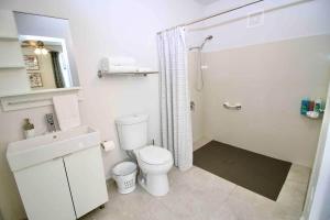 a white bathroom with a toilet and a shower at 1.1• Disabled • Generator • 1st Floor • Parking in Mayaguez