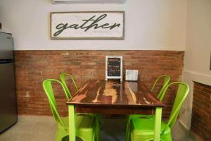 a wooden table with green chairs and a sign on a wall at 1.1• Disabled • Generator • 1st Floor • Parking in Mayaguez +66 photos