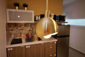 a kitchen with a large gold pot hanging from the ceiling at 1.7 • Balcony • Generator • Parking • 2nd Floor in Mayaguez +55 photos