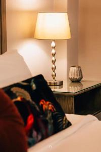 a lamp sitting on a table next to a bed at MARON in Kalavrita