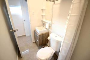 a bathroom with a white toilet and a sink at 1.6 • Balcony • Generator • Parking • 2nd Floor in Mayaguez