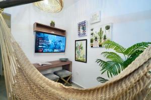 a hammock in a room with a desk and a tv at 1.4 • Generator • 1st Floor • Parking • 238sf in Mayaguez