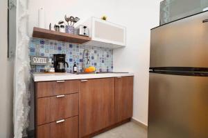 a kitchen with wooden cabinets and a stainless steel refrigerator at 1.4 • Generator • 1st Floor • Parking • 238sf in Mayaguez +60 photos