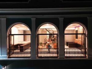 three windows of a building with a view of a balcony at 5.4 Loft • Lobby • Generator • Parking • 2nd Floor in Mayaguez