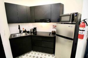 a small kitchen with a refrigerator and a microwave at 5.1 Loft • Lobby • Generator • Parking • 2nd Floor in Mayaguez