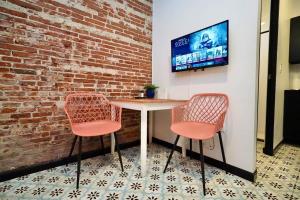 two chairs and a table in front of a brick wall at 5.1 Loft • Lobby • Generator • Parking • 2nd Floor in Mayaguez