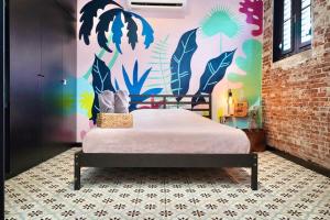 a bedroom with a bed and a colorful wall at 5.1 Loft • Lobby • Generator • Parking • 2nd Floor in Mayaguez