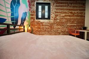 a bed in a room with a brick wall at 5.1 Loft • Lobby • Generator • Parking • 2nd Floor in Mayaguez +42 photos