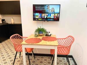 a table with two chairs and a tv on a wall at 5.6 Loft • Lobby • Generator • Parking • 2nd Floor in Mayaguez