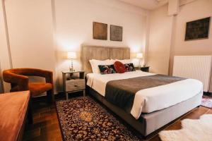 a bedroom with a large bed and a chair at MARON in Kalavrita