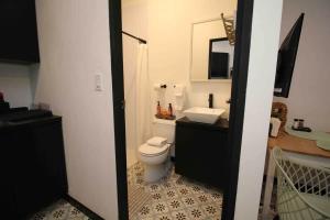 a bathroom with a white toilet and a sink at 5.2 Loft • Lobby • Generator • Parking • 2nd Floor in Mayaguez