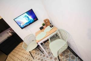 a room with a table and two chairs and a television at 5.2 Loft • Lobby • Generator • Parking • 2nd Floor in Mayaguez