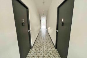 a hallway with two black doors and a tile floor at 5.3 Loft • Lobby • Generator • Parking • 2nd Floor in Mayaguez