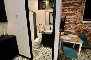 a bathroom with a toilet and a table and chairs at 5.3 Loft • Lobby • Generator • Parking • 2nd Floor in Mayaguez