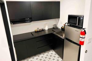 a small kitchen with a refrigerator and a microwave at 5.5 Loft • Lobby • Generator • Parking • 2nd Floor in Mayaguez