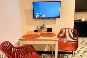 a table with two chairs and a television on a wall at 5.5 Loft • Lobby • Generator • Parking • 2nd Floor in Mayaguez