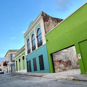 a green and white building on the side of a street at 5.7 Penthouse • Generator • Parking • 3rd floor in Mayaguez