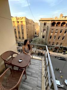 a woman sitting at a table on a balcony at Park Plaza Haven in Cairo