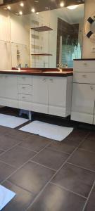 a bathroom with white cabinets and a large mirror at Jolie maison d'hôtes in Changé