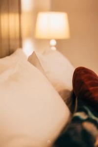 a person is sitting on a bed with a lamp at MARON in Kalavrita
