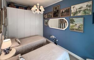 two beds in a room with blue walls at 2 Bedroom Awesome Apartment In Chiavari in Chiavari
