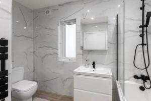 a bathroom with a toilet and a sink and a shower at 3BD in Hendon in The Hyde