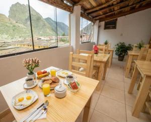 a table with breakfast food on it in a restaurant at Sunshine in Ollantaytambo