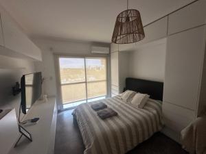 a bedroom with a bed and a large window at Vista Haus in General Sarmiento