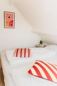 two white beds in a room with a picture on the wall at Vakantiehuis dicht bij het strand in Ouddorp