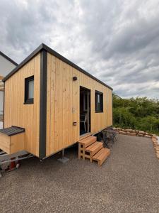 a small wooden cabin with a table and benches at Tiny Stay Guesthouse - Würzburg in Würzburg