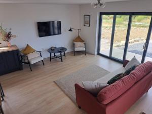 a living room with a red couch and a tv at Muckish Hideaway in Crockglass