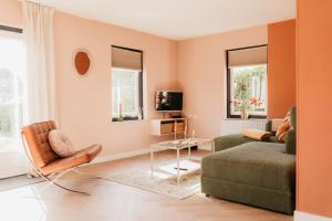 a living room with a couch and a chair at Vakantiehuis dicht bij het strand in Ouddorp