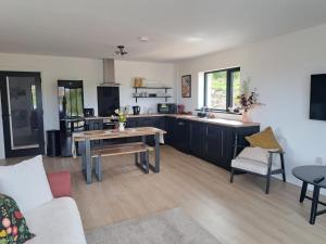 a living room with a table and a kitchen at Muckish Hideaway in Crockglass