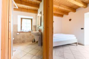 ein Schlafzimmer mit Bett und Badezimmer in der Unterkunft B&B Arlanch 8 in Vallarsa + 53 Fotos