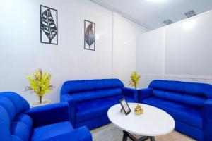 a living room with blue couches and a white table at RiadRiad Bollywood-Dream Stay B in Benguerir +2 photos