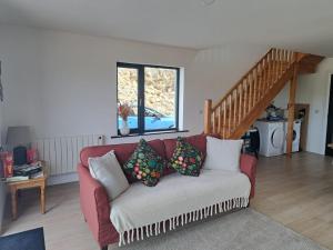 a living room with a red couch with pillows at Muckish Hideaway in Crockglass