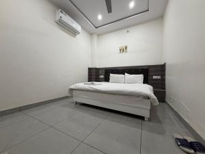 a bedroom with a bed in a white room at Hotel Velga in Kurukshetra