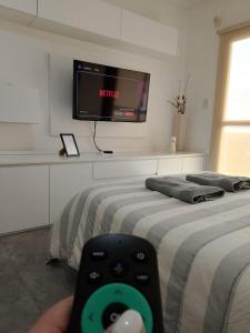 a person holding a remote control in front of two beds at Vista Haus in General Sarmiento