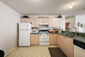 a kitchen with a white refrigerator and a sink at Patio Villa in Santo Domingo in The Villages