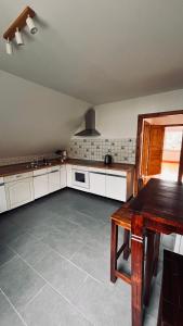 a kitchen with white cabinets and a table in it at Die Ferienwohnung im Grünen in Lichtenau