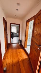 an empty room with a wooden floor and an open door at Die Ferienwohnung im Grünen in Lichtenau