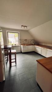 a large kitchen with a table and a large window at Die Ferienwohnung im Grünen in Lichtenau