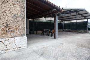 a patio with a table and chairs under a roof at Cerenea House BiancAntò in Isola del Liri